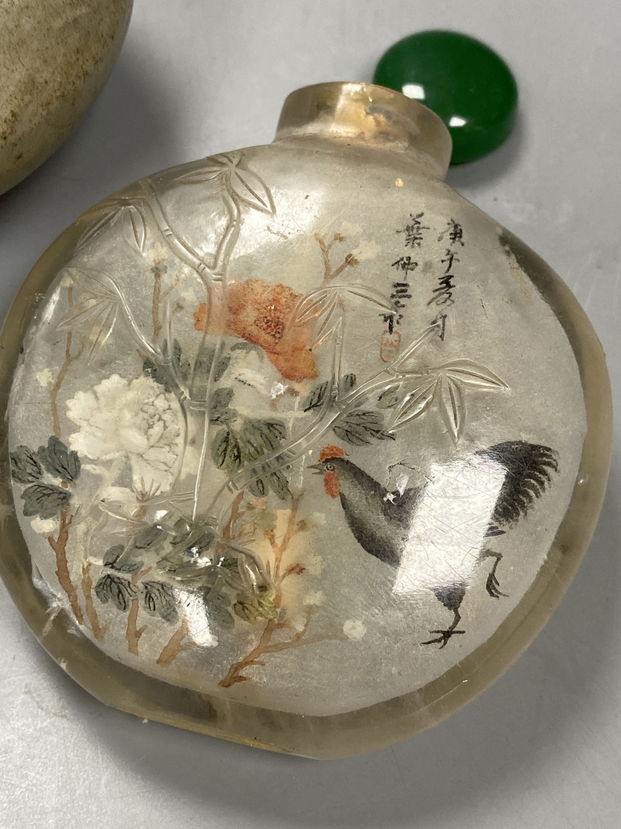 A Chinese inside painted rock crystal snuff bottle and inside painted glass snuff bottle and a small Chinese celadon jarlet, tallest 8c